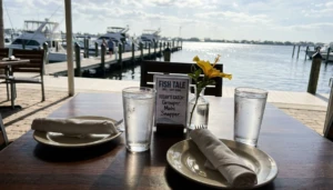 Waterfront patio table at Fish Tale Grill, one of the best food spots in Cape Coral, with marina views and fresh daily-catch menu card.