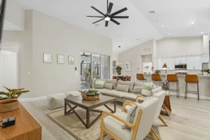 Modern open-concept living room and kitchen with neutral tones and patio access in Cape Pelican Cape May vacation rental