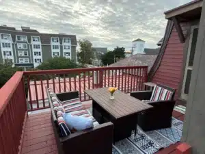 Coastal deck with nautical railings and wicker seating overlooking waterfront village in Cape May