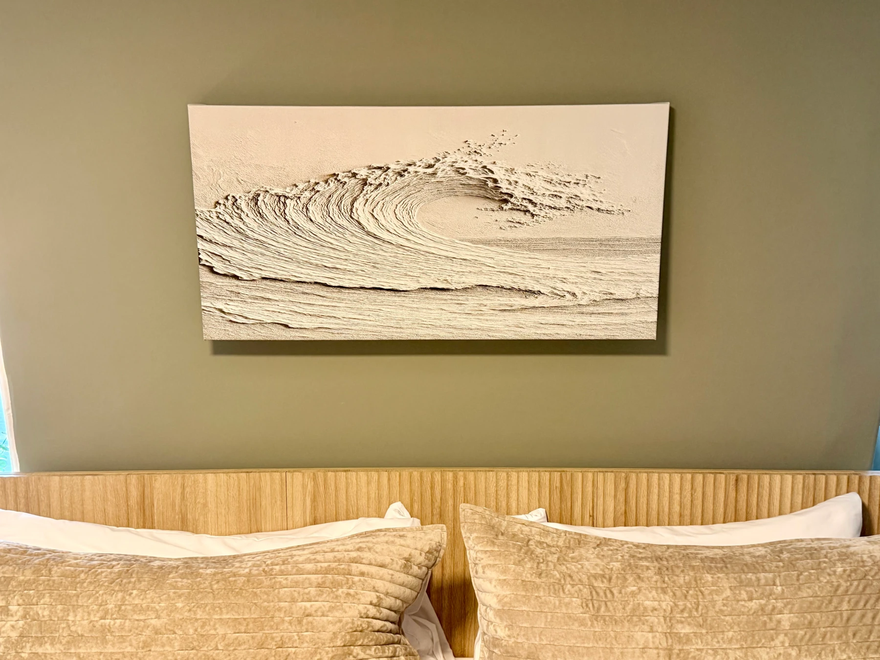 Serene bedroom with wave artwork above wooden headboard, neutral coastal decor in Cape Wave