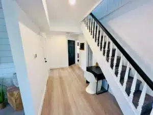 Modern entryway and staircase in a Cape May vacation rental home with light wood floors