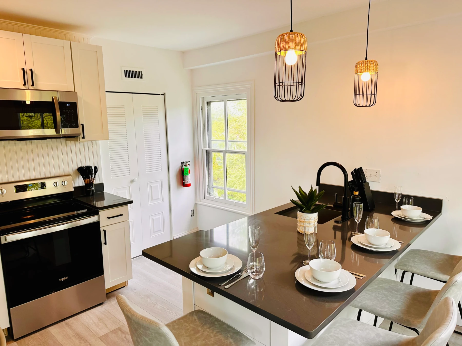 Modern open-concept kitchen and dining area with black cabinetry and island seating in Cape May