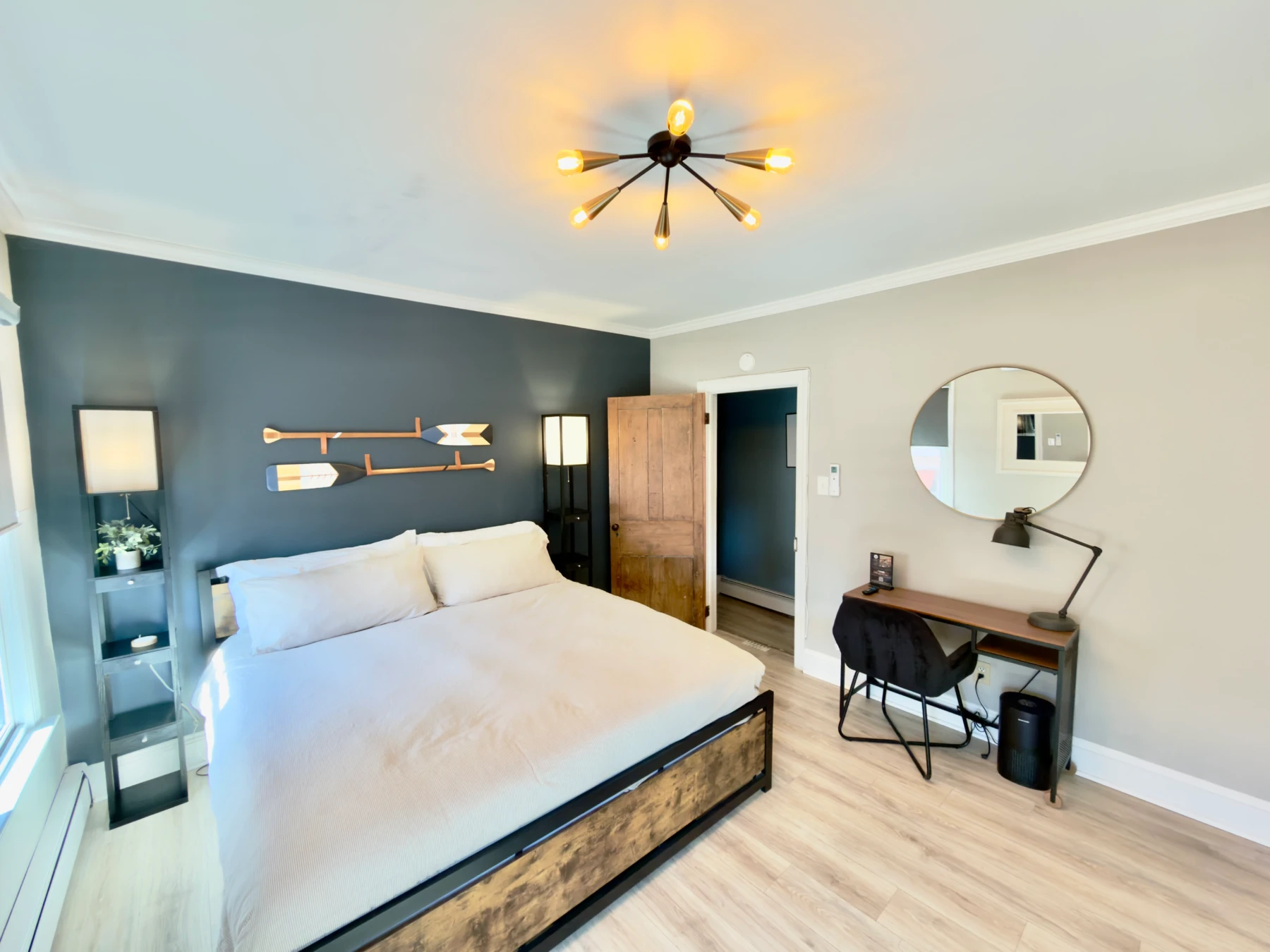 Modern coastal bedroom with queen bed, teal accent wall and nautical decor in Cape May condo