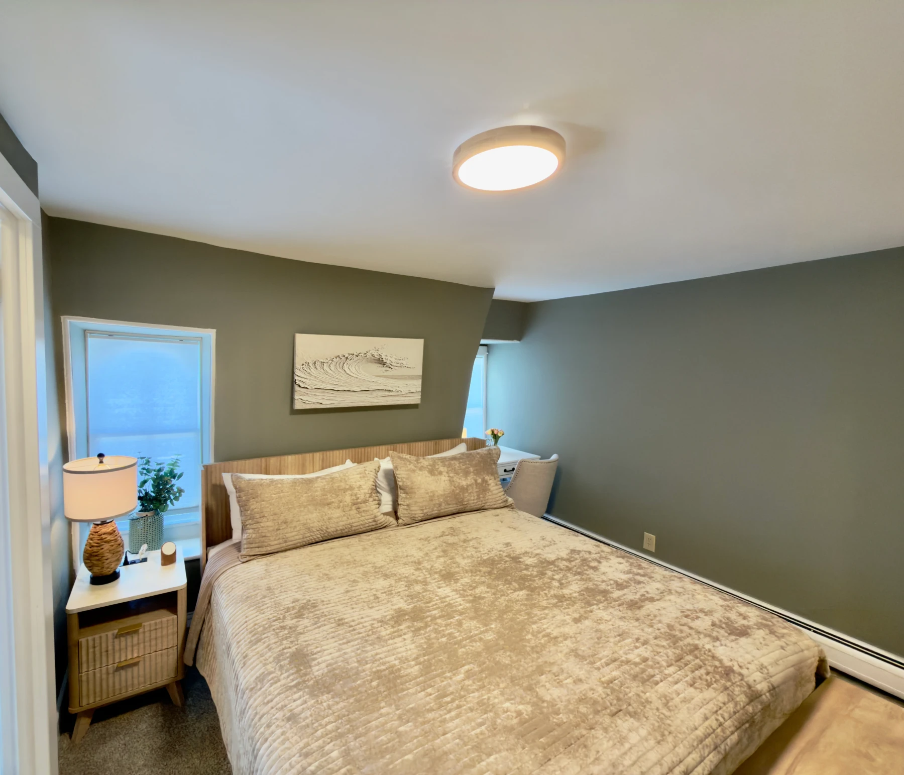 Coastal bedroom with sage green walls, ocean view, and modern decor in Cape May beach rental