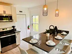 Modern open-concept kitchen and dining area with black cabinetry and pendant lighting in Cape May