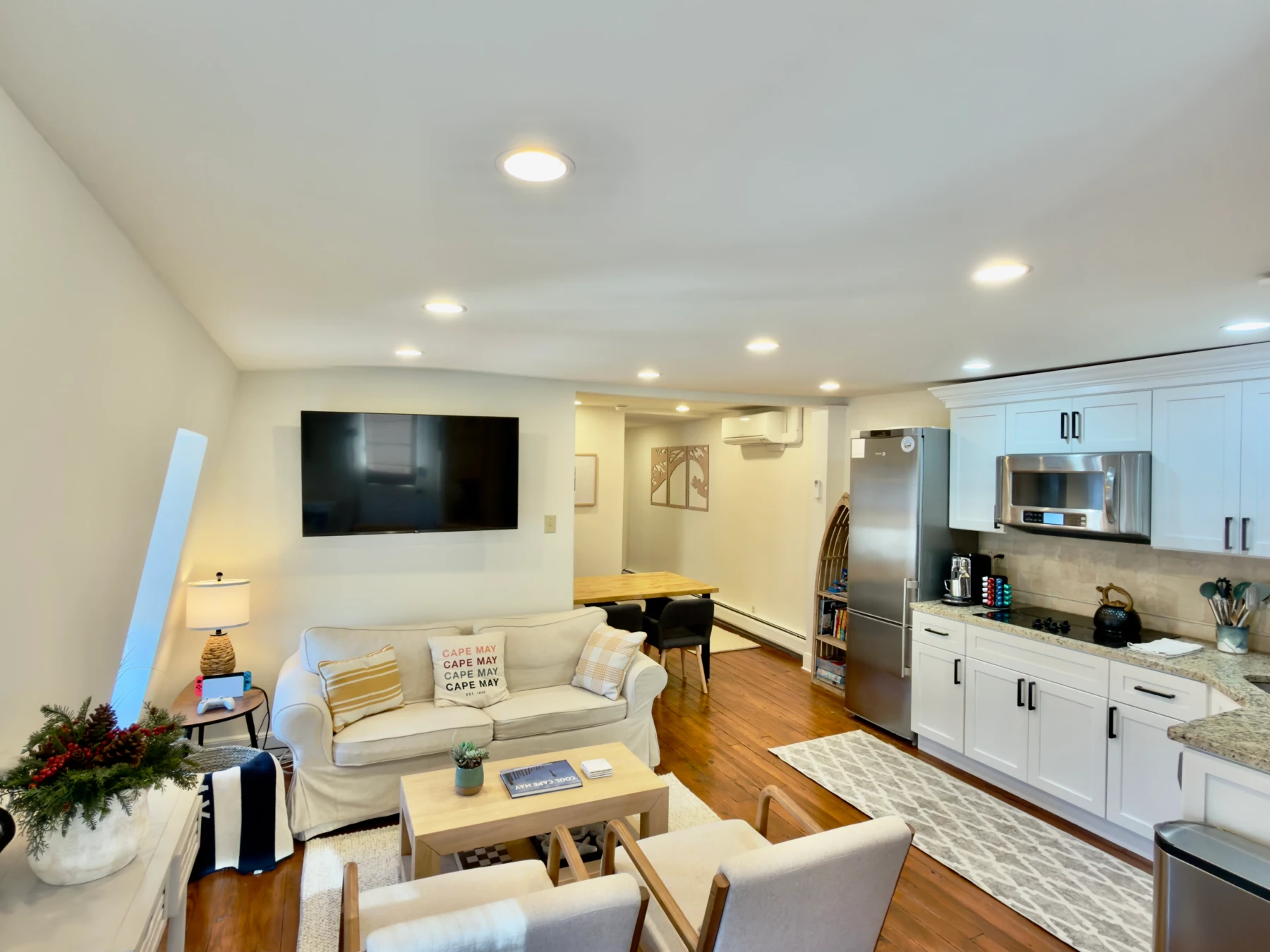 Modern open-concept basement living room with integrated kitchen and stainless steel appliances in Cape May, NJ vacation