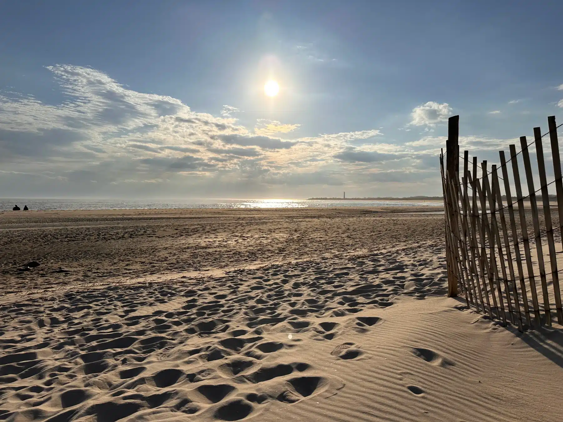 Sandy beach with wooden dune fence and ocean view at sunset in Cape May, NJ
